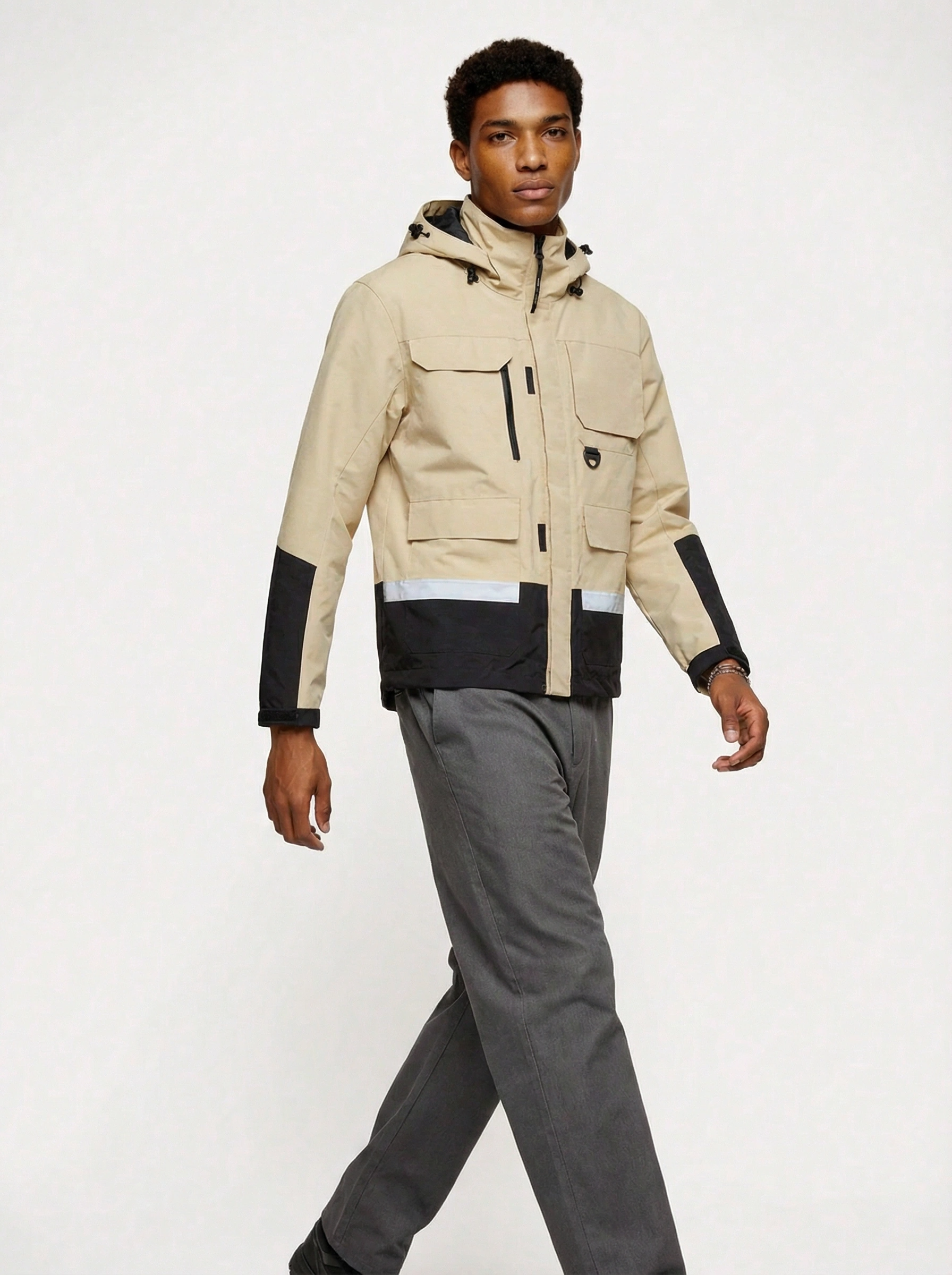 Man wearing a beige and black jacket with gray pants