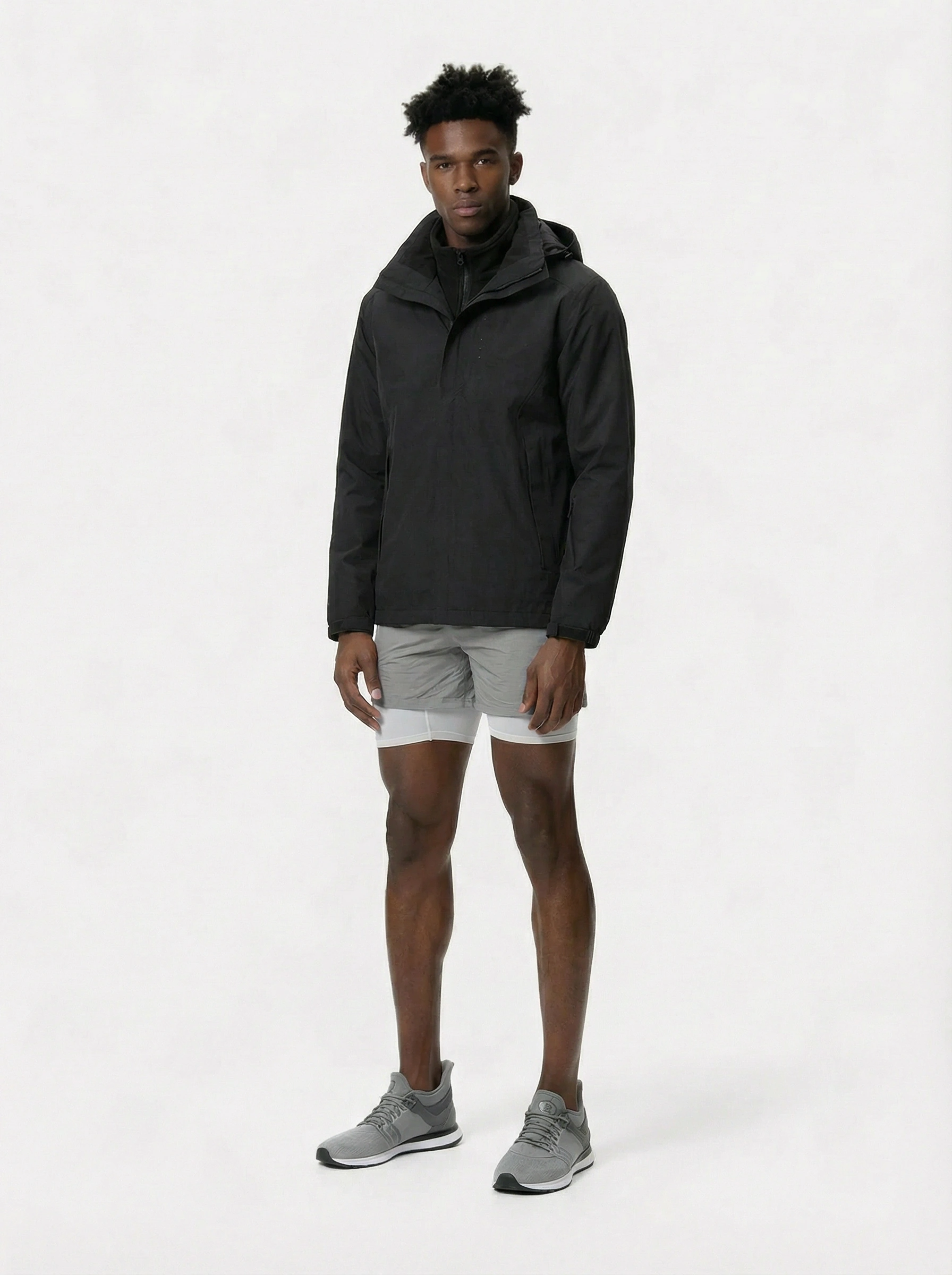 Person wearing a black jacket and gray shorts