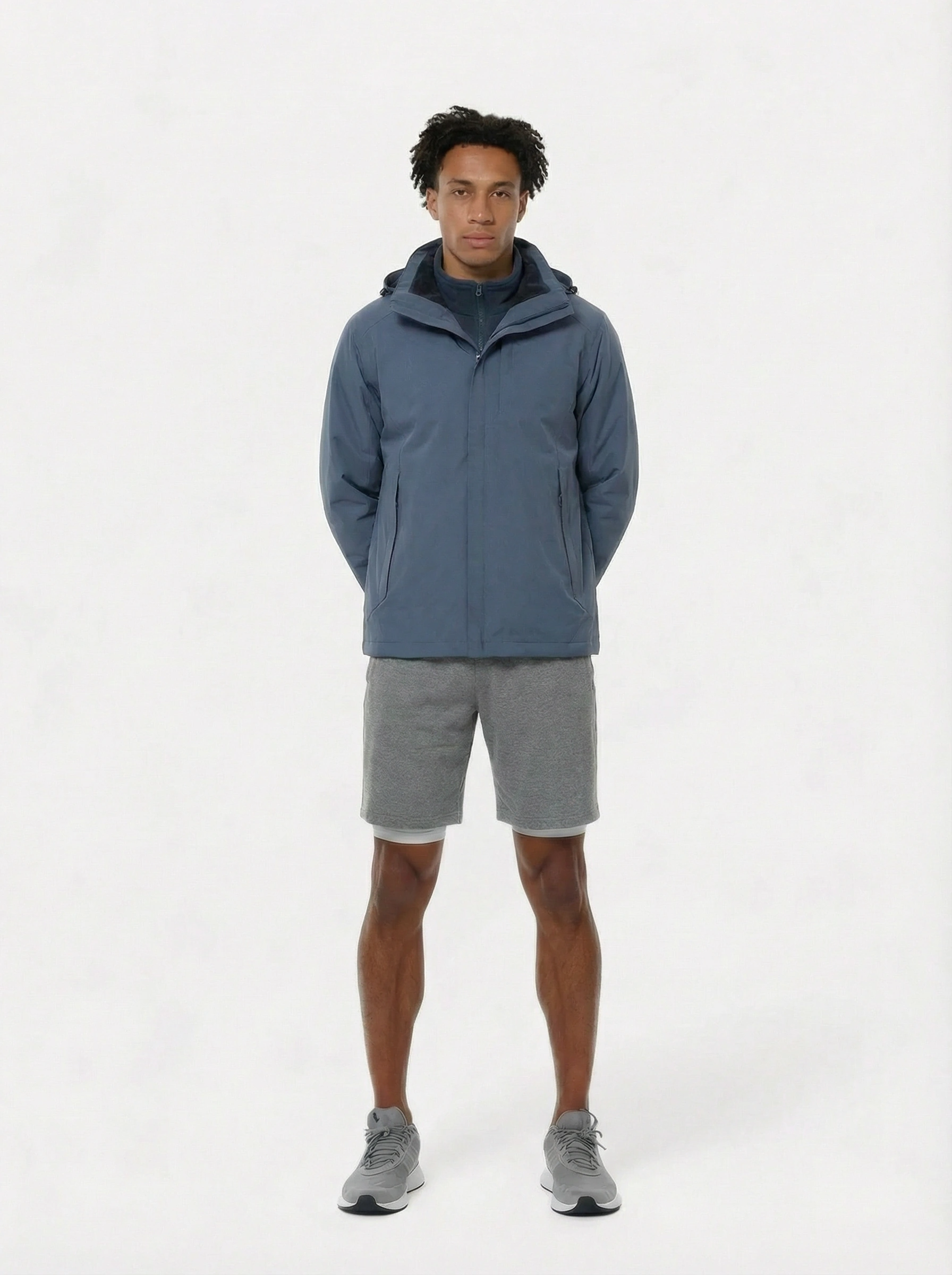 Person wearing a blue jacket and gray shorts