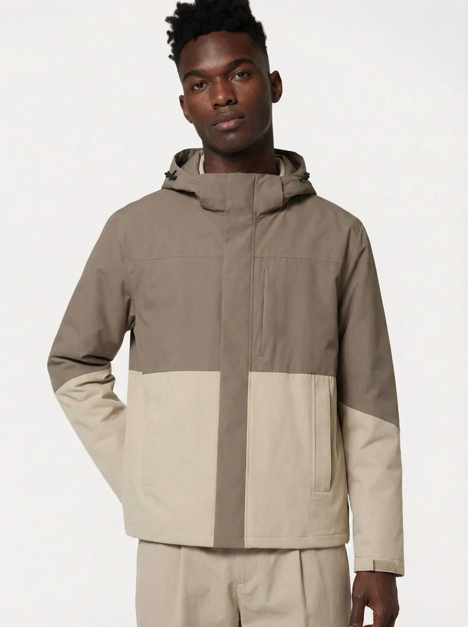 Man wearing a two-tone jacket with a neutral color scheme 