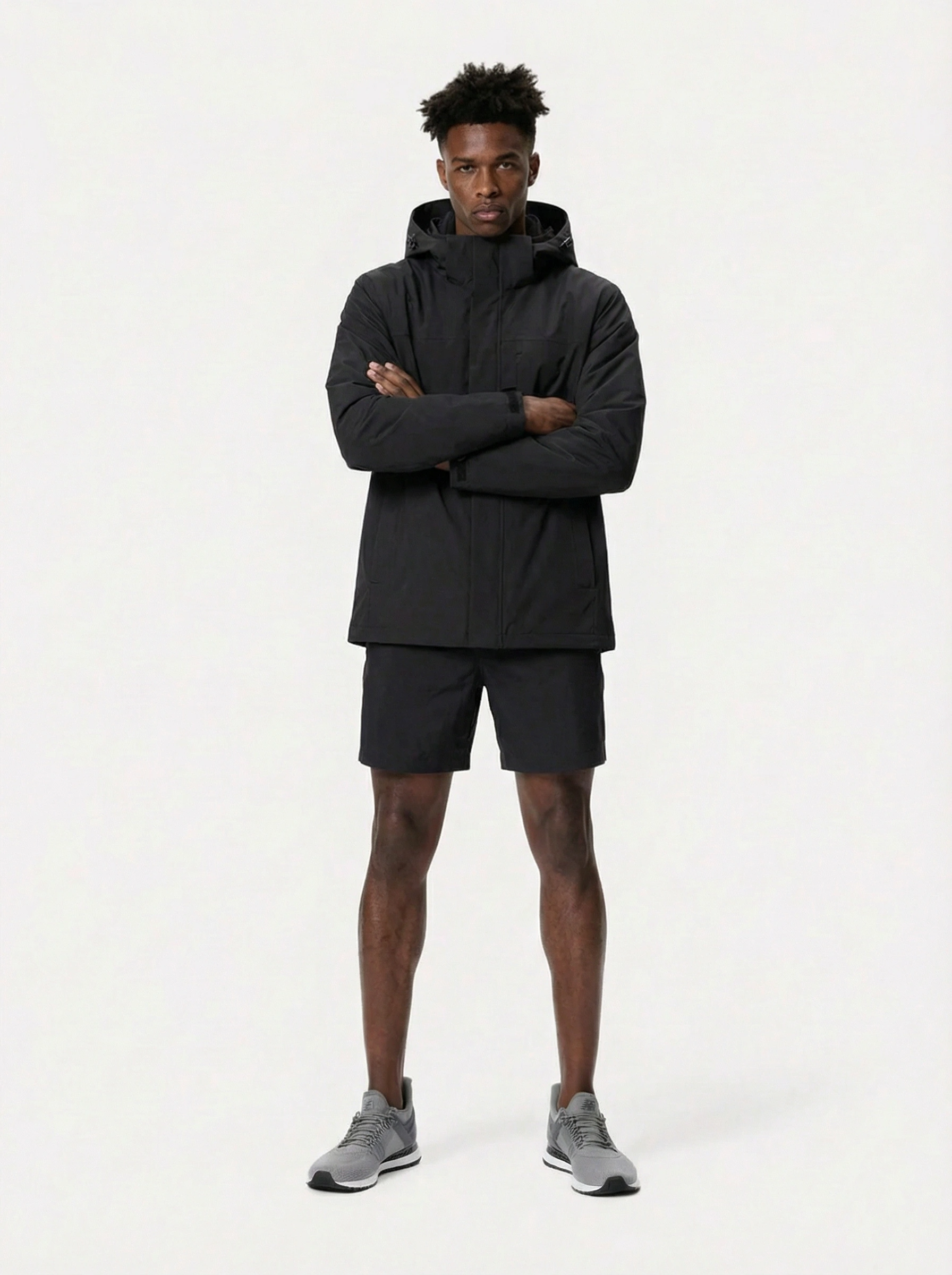 Man wearing a black jacket and shorts 